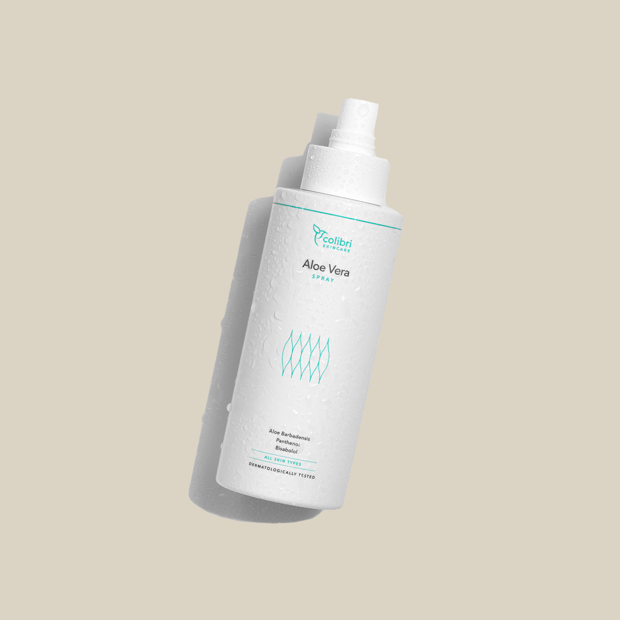 Weiße Flasche Aloe Vera Spray mit Wassertropfen auf beigem Hintergrund, leicht geneigt stehend.