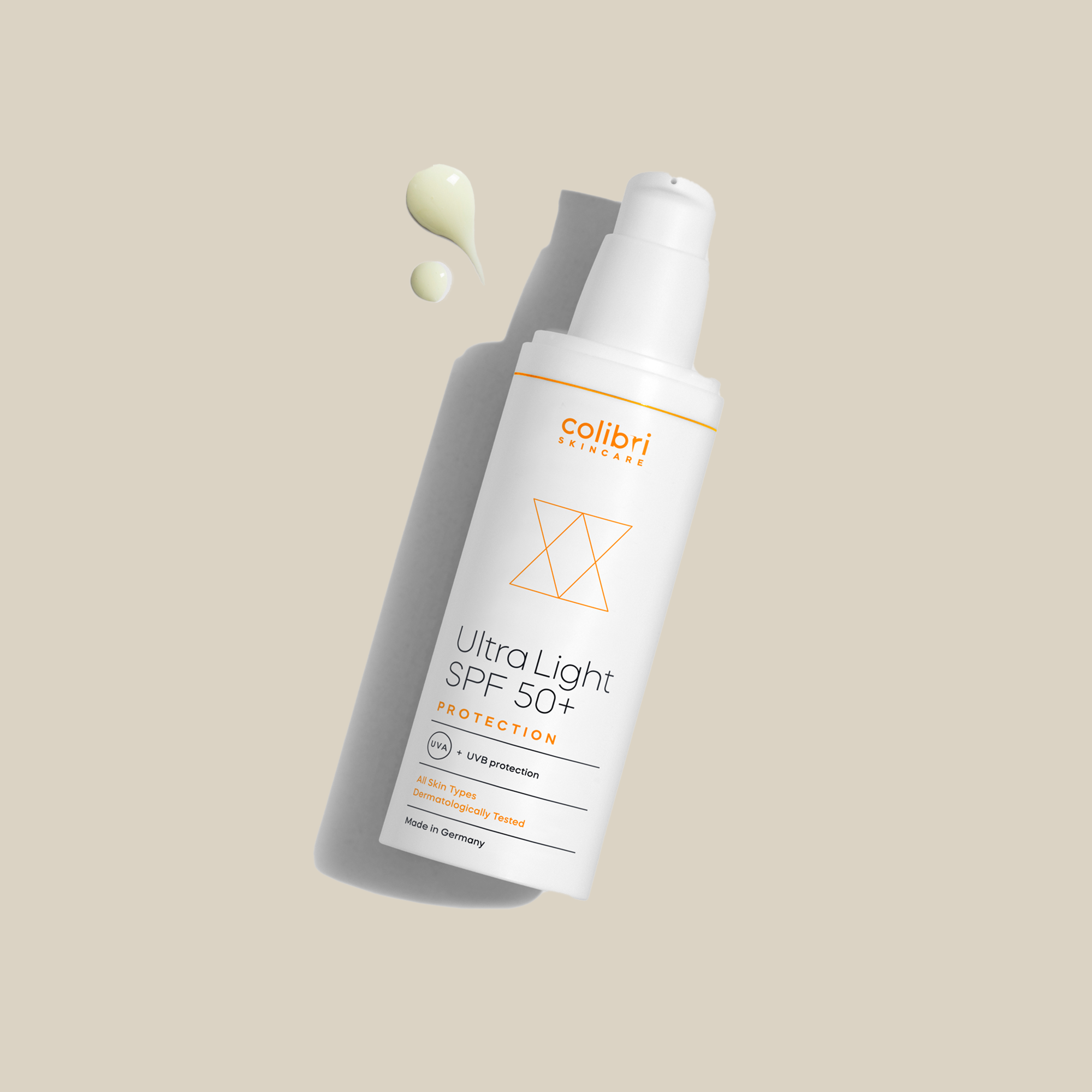 Flasche Colibri Ultra Light SPF 50+ auf beigem Hintergrund mit einem Tropfen Sonnencreme daneben.