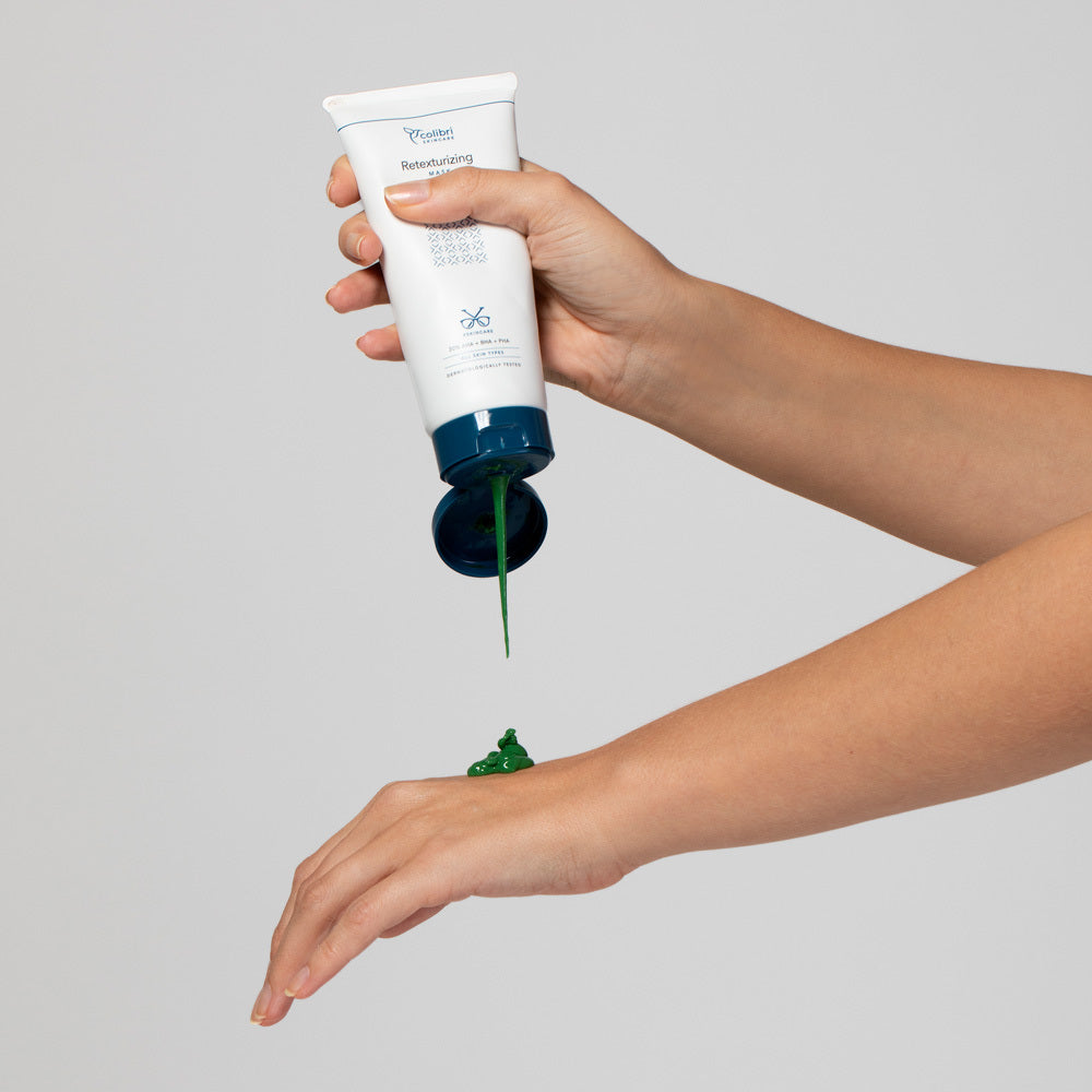 Ein Arm drückt grüne Creme aus einer Tube auf den Handrücken.