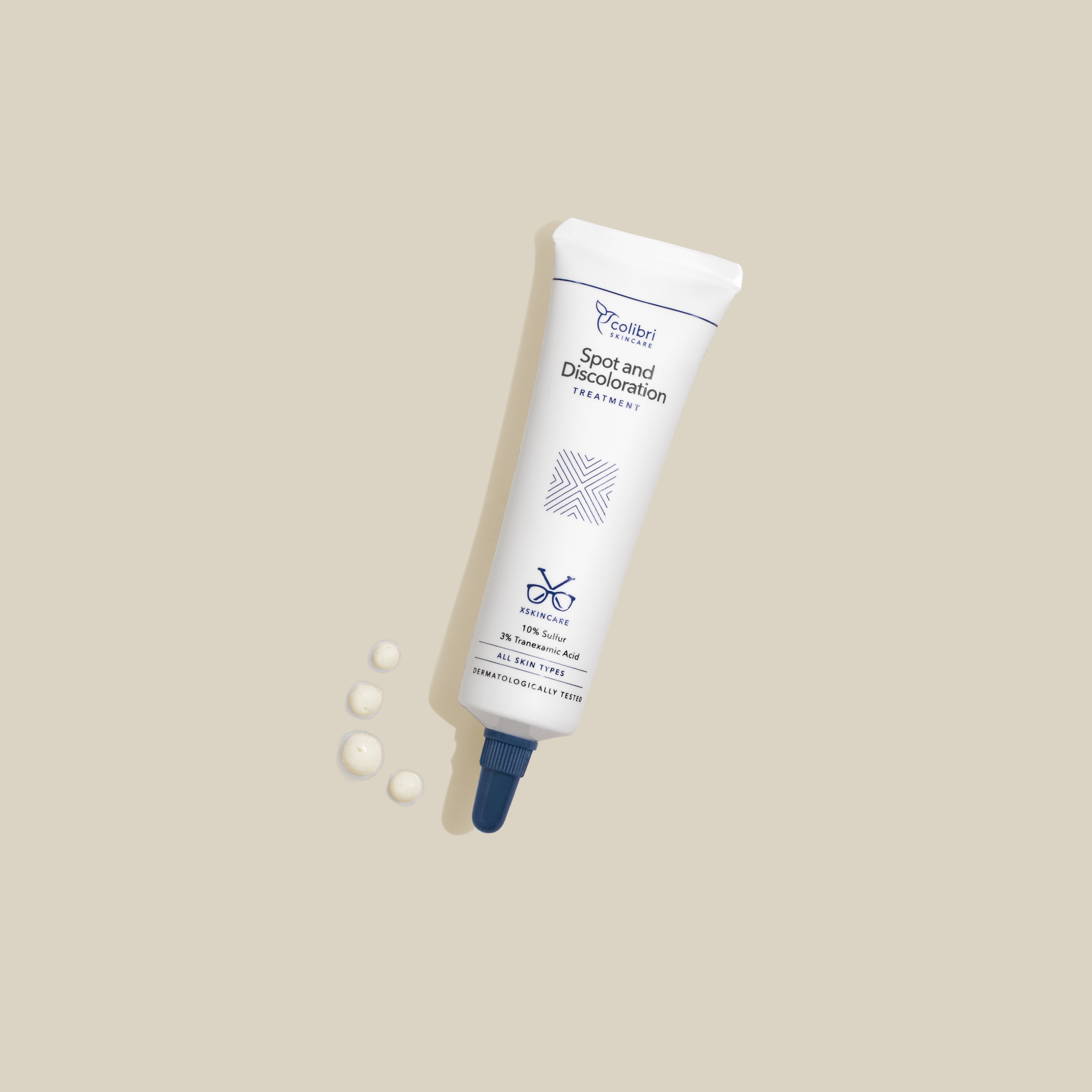 Eine Tube Hautpflegemittel mit blauer Kappe liegt auf beigem Hintergrund. Neben der Tube sind drei Cremetropfen.