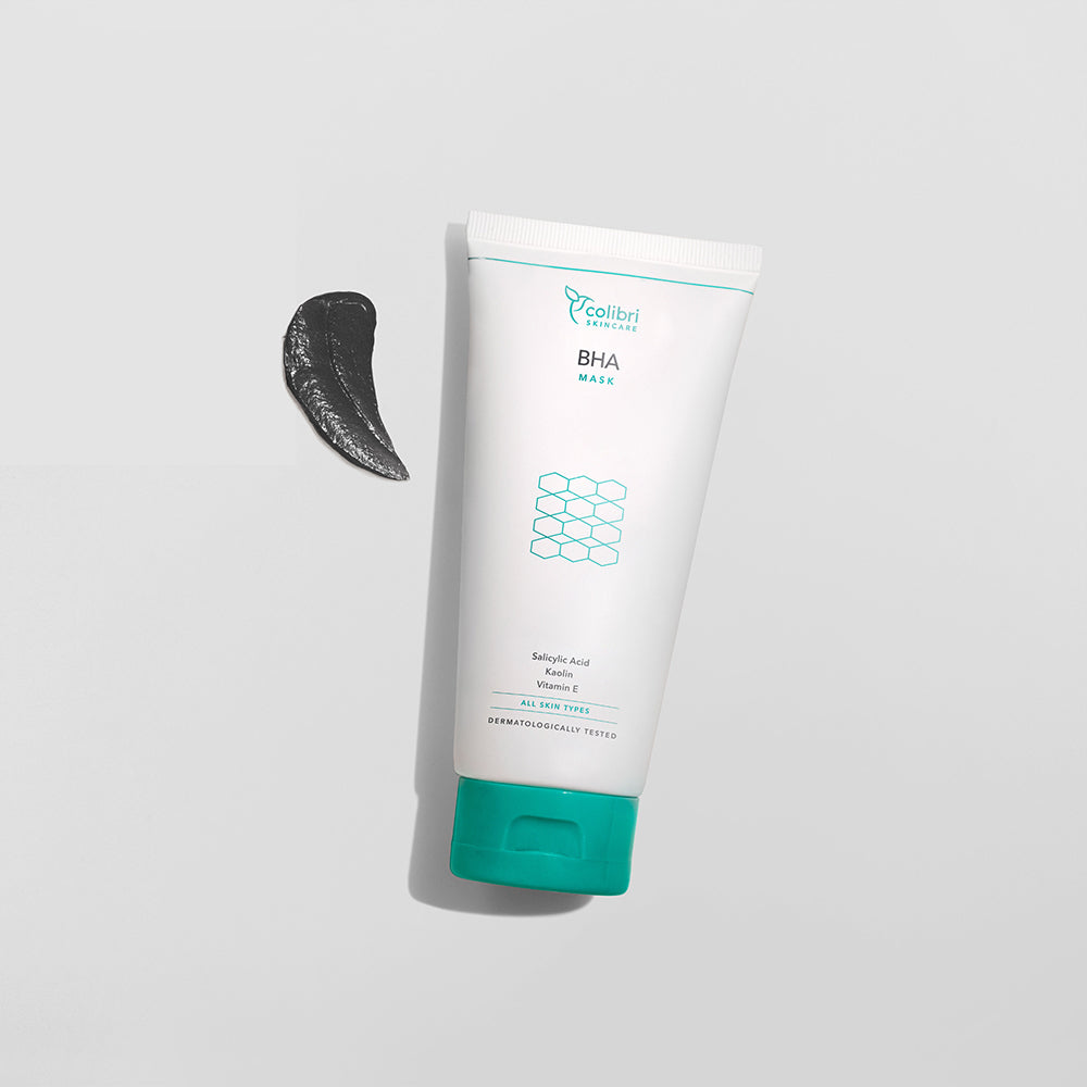 Weiße Tube mit BHA-Maske und ein schwarzer Klecks auf hellem Hintergrund.